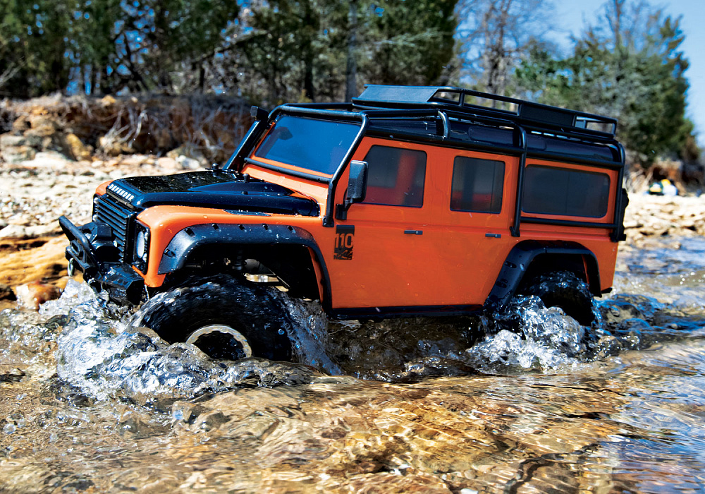 8011A-Defender-Orange-water-woods-side-left